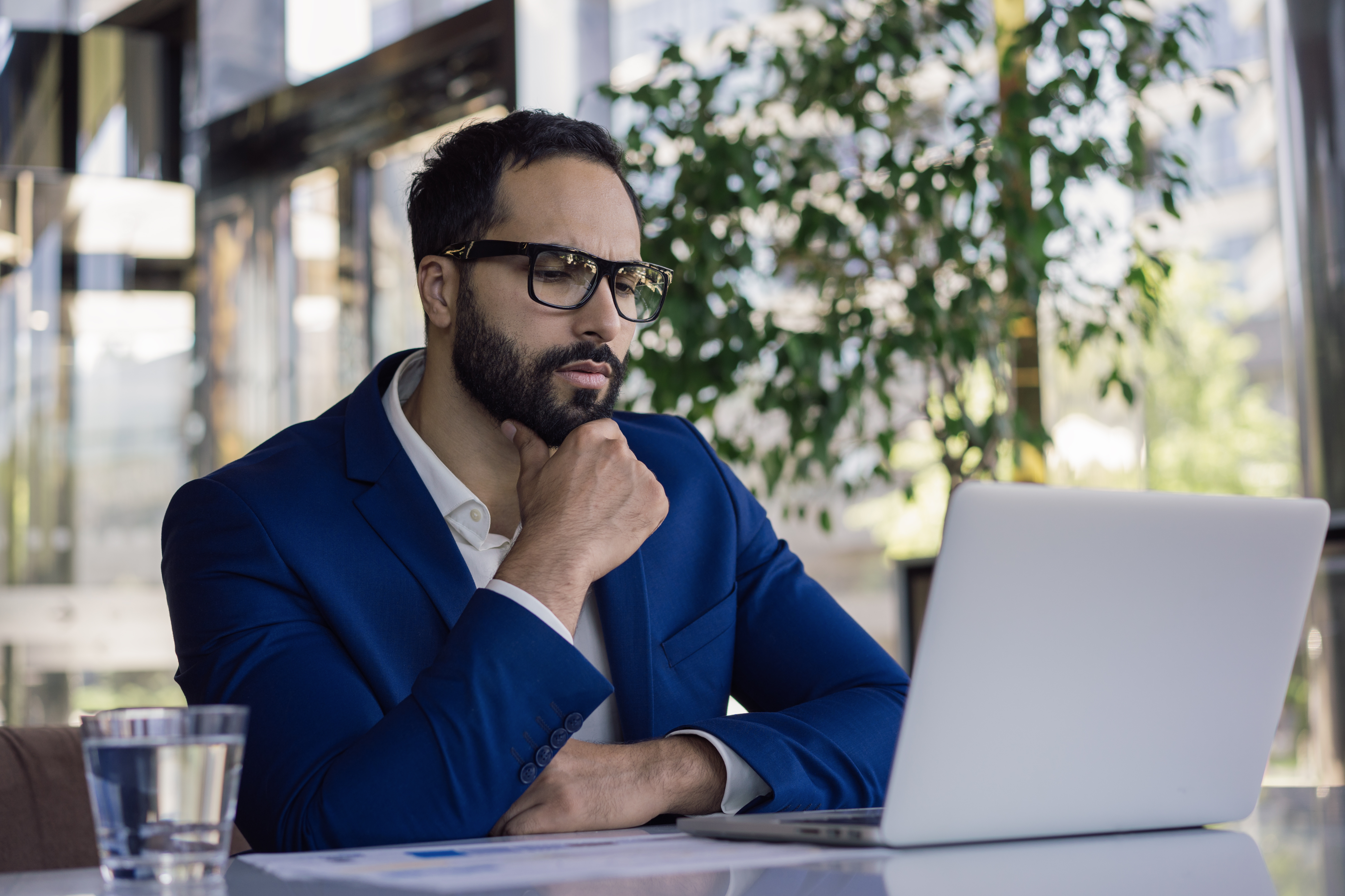 Man waring suit in front of laptop