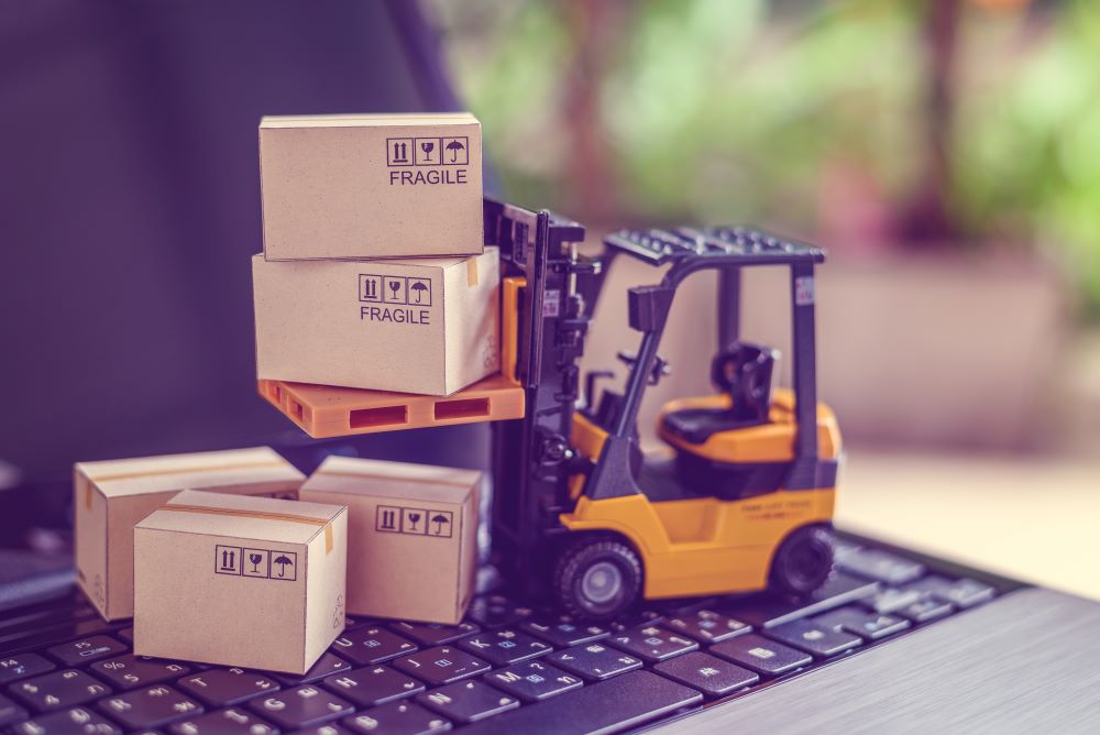 Forklift toy driving over laptop keyboard
