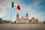 Mexican flag in foreground, in front of the historic Plaza Zócalo in Mexico City
